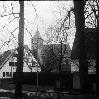 Historic half-timbered buildings in misty winter scene.
