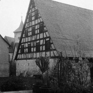 Traditional half-timbered farmhouse with steep gabled roof.
