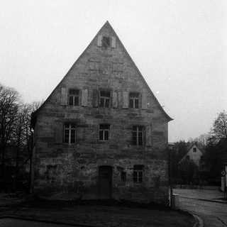 Historic stone building with steep gable roof.