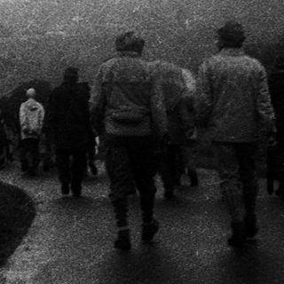 People walking along a foggy road.