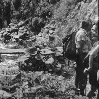Hikers exploring misty, narrow mountain canyon.