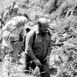 Mountaineers ascending rugged, snow-covered rocky terrain.