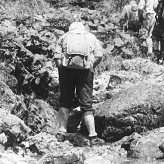 People hiking through rugged mountainous terrain.