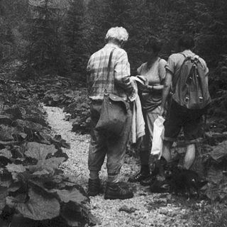 Two hikers carrying backpacks on a rocky trail.