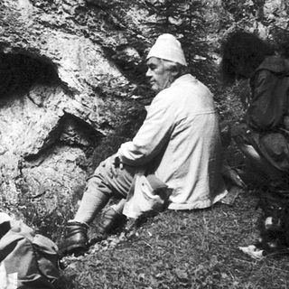 Archaeologists examining prehistoric cave entrance.