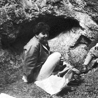 Archaeologists examining prehistoric cave entrance.