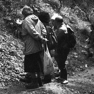 People examining large rock formations outdoors.