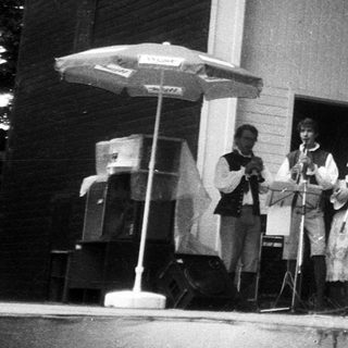Traditional folk band performing outdoors in traditional attire.