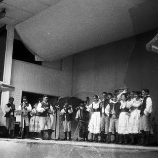 Traditional folk band performing outdoors in traditional attire.