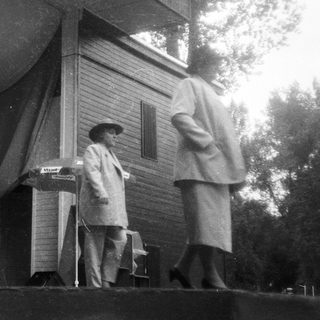 Vintage outdoor performance with pianist and singer.