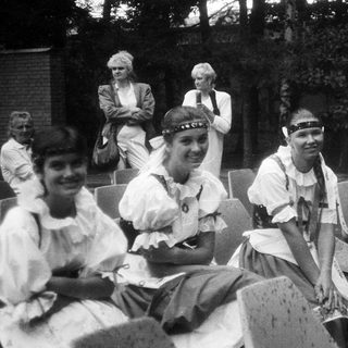 Group of people in traditional folk attire, likely at an outdoor gathering.