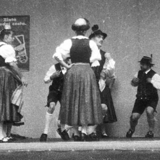 Traditional folk dancers and musicians performing on stage.
