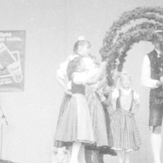 Indoor event with fog, stage performance, traditional costumes.