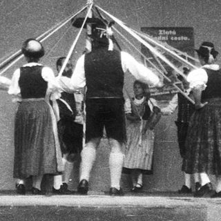 Traditional folk dance with maypole and musicians.