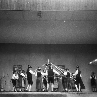 Traditional folk dance with maypole and musicians.