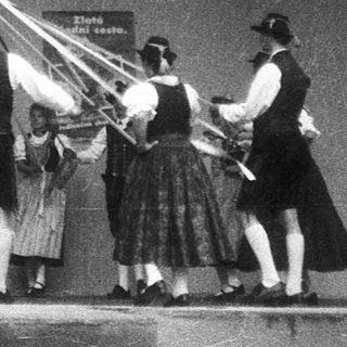 Traditional folk dance with maypole and musicians.