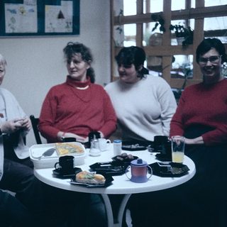 Group of five people enjoying a meal together indoors.