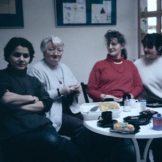 Group of five people enjoying a meal together indoors.