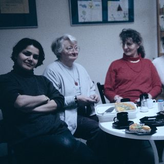 Group of five women sitting together indoors at a meal.