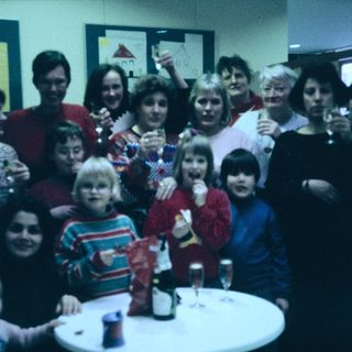 Group celebration with adults and children at a festive indoor gathering.