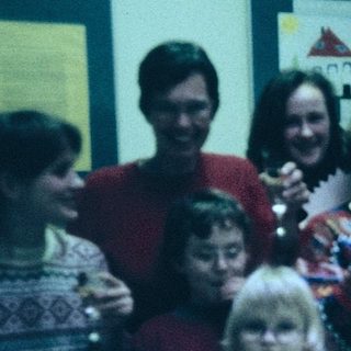 Group celebration with adults and children at a festive indoor gathering.