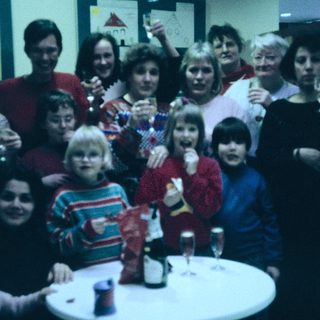 Group celebration with adults and children at a festive indoor gathering.