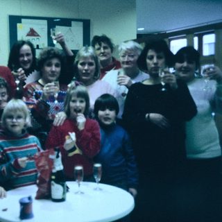 Group celebration with adults and children at a festive indoor gathering.