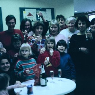 Group celebration with adults and children indoors.