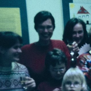 Group celebration with adults and children indoors.