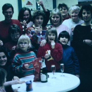 Group celebration with adults and children indoors.