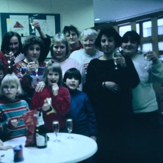 Group celebration with adults and children indoors.