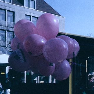 Vintage parade truck with pink balloons.