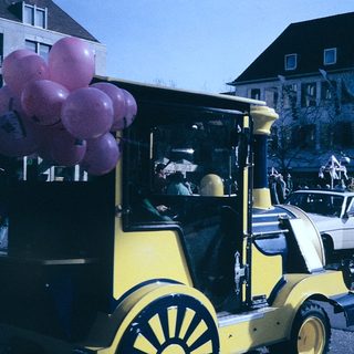 Vintage parade truck with pink balloons.