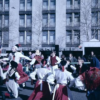 Traditional folk dancers in colorful costumes performing outdoors.