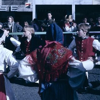 Traditional folk dancers in colorful costumes performing outdoors.