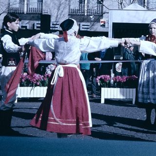 Traditional folk dancers performing outdoors in cultural attire.