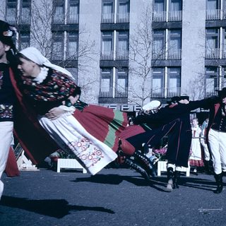 Traditional folk dancers in colorful costumes performing outdoors.