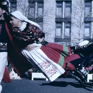 Traditional folk dancers in colorful costumes performing outdoors.