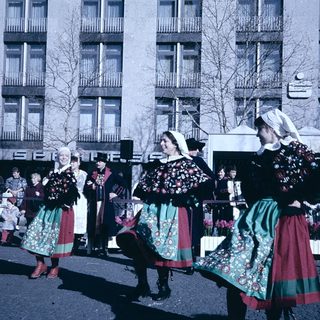 Traditional folk dancers in colorful costumes performing outdoors.