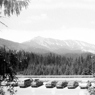Snowy mountain parking lot with cars.