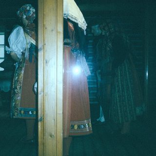 Dark interior with traditional ceremonial umbrellas and lanterns.