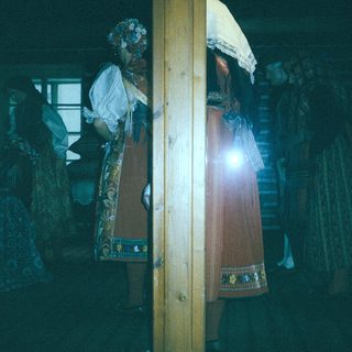 Dark interior with traditional ceremonial umbrellas and lanterns.