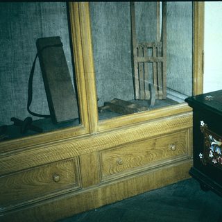 Antique wooden furniture with ornate chest and old tools.