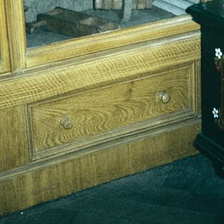 Antique wooden furniture with ornate chest and old tools.