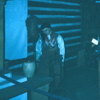 Historic blacksmiths working in a rustic forge.