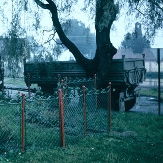 Vintage cemetery with old trucks and gravestones.