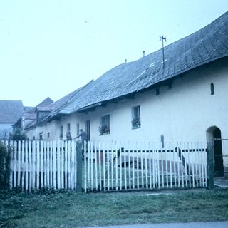 Rural buildings with whitewashed walls and wooden fencing.