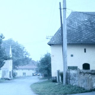 Rural village street with small chapel and houses.
