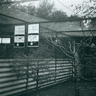 Enclosed animal exhibit with informational signs.