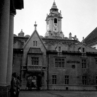 Historic building with "Muzeum" sign and clock tower.
